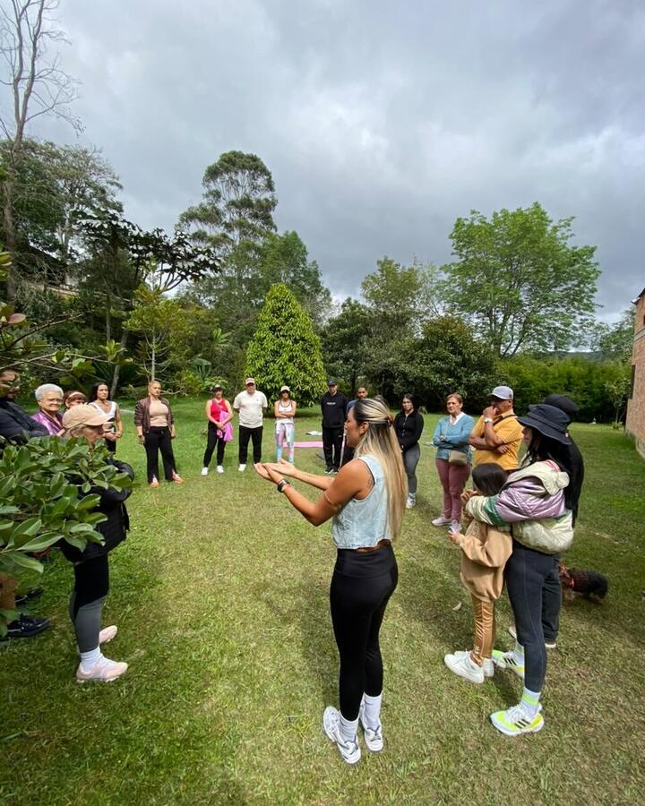 DebAnanda guía a un grupo reunido en un jardín
